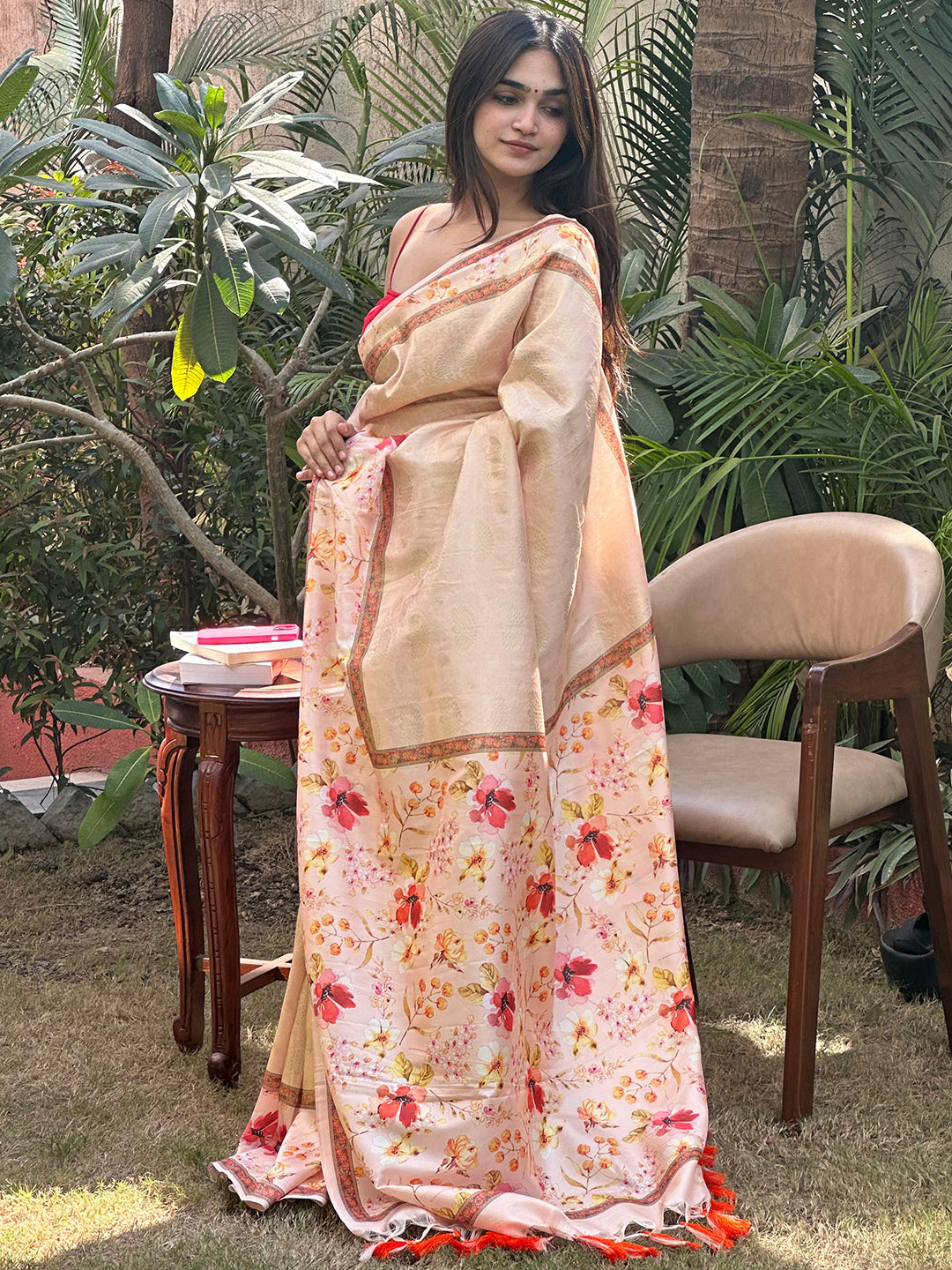 Woman posing in peach floral print Kanjivaram saree outside