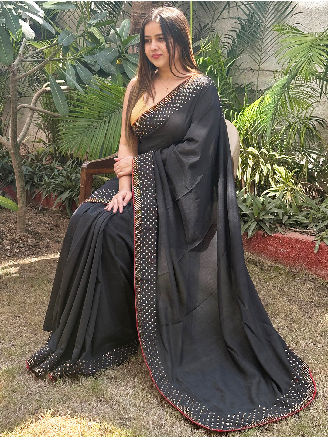 Black Vichitra Silk Saree with Swarovski Stones, seated outdoors