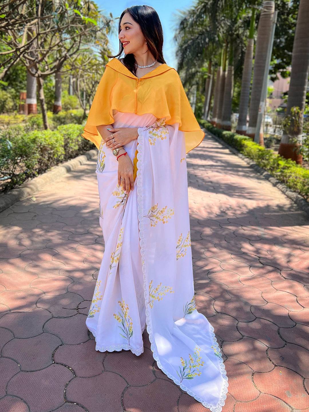 Woman wearing white floral satin georgette saree with yellow blouse