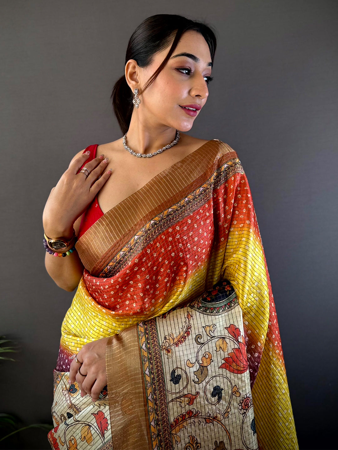 Traditional Silk Blend Bandhani Print Saree with vibrant red, yellow, and beige hues, featuring intricate patterns and a rich border design.