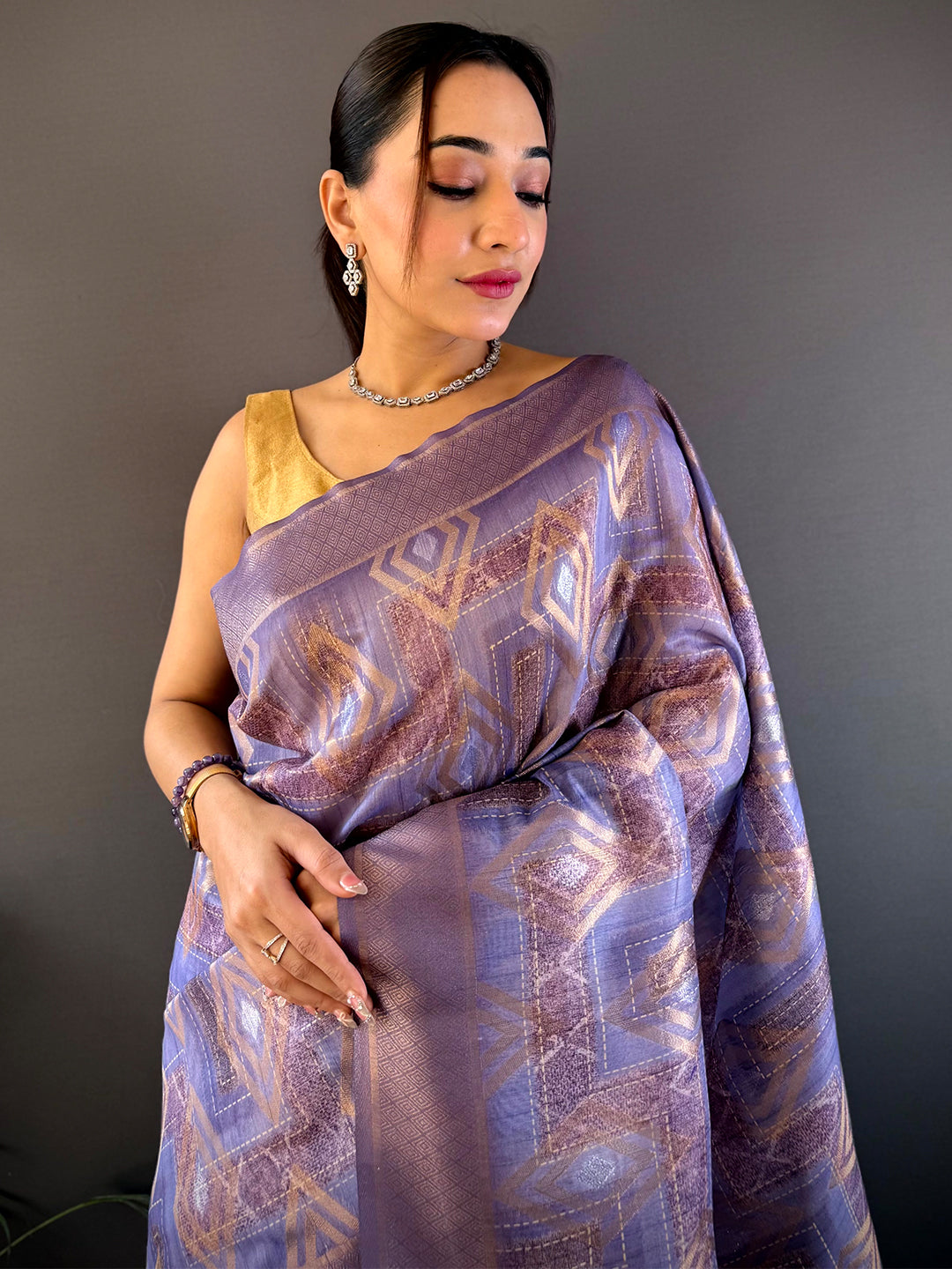 Lavender Banarasi Silk Katan Geometric Saree with intricate gold patterns, draped elegantly. Perfect for weddings and festive occasions.