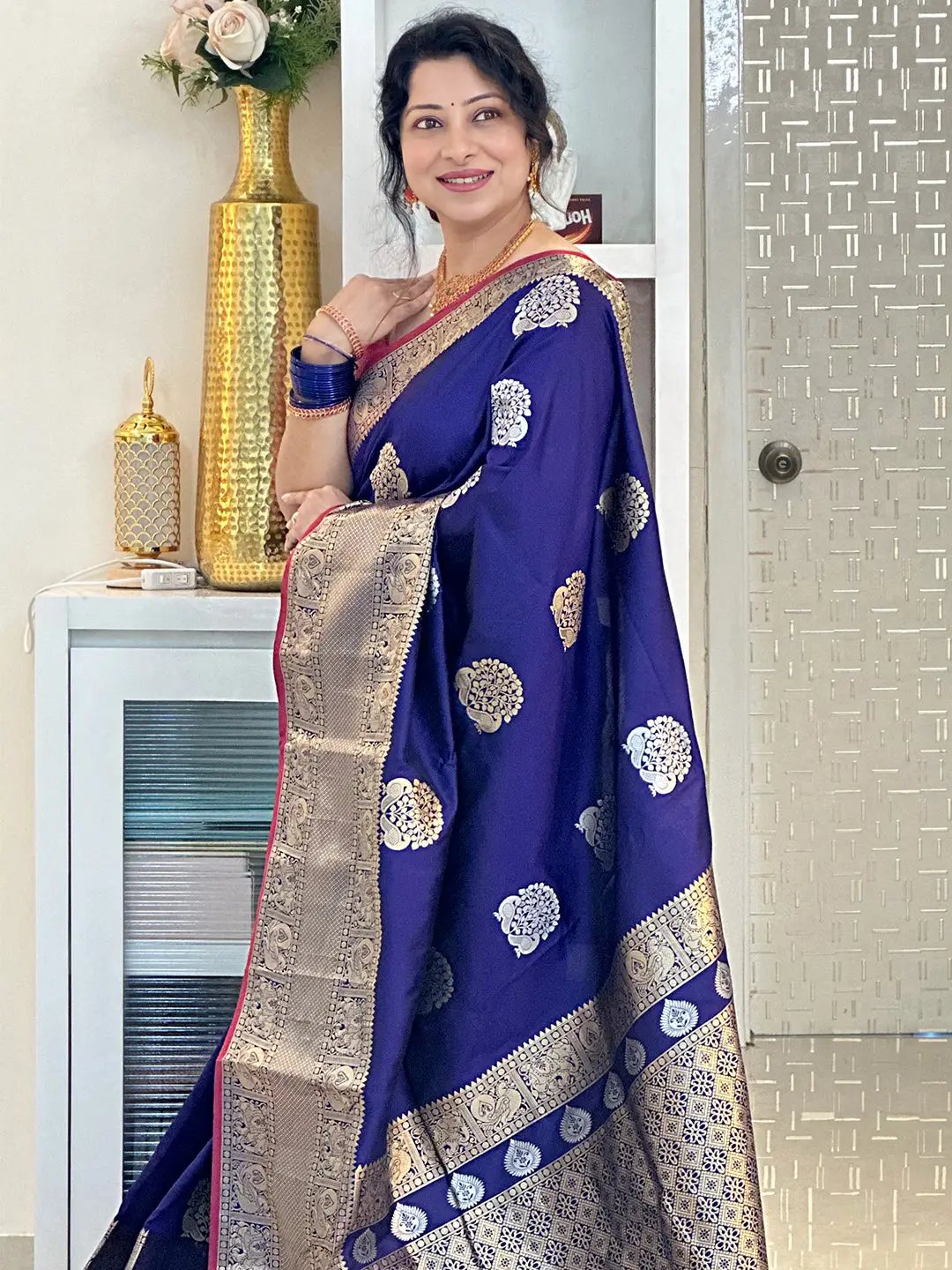 Woman in purple Banarasi silk saree featuring Kanchi zari motifs.