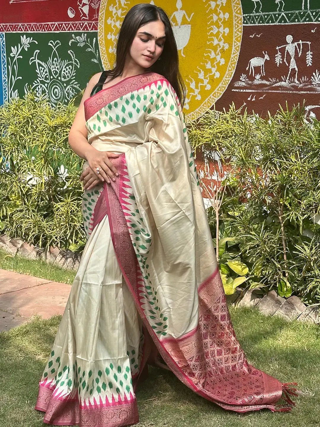 Cream Banarasi silk saree with pink Patola pallu, outdoor scene