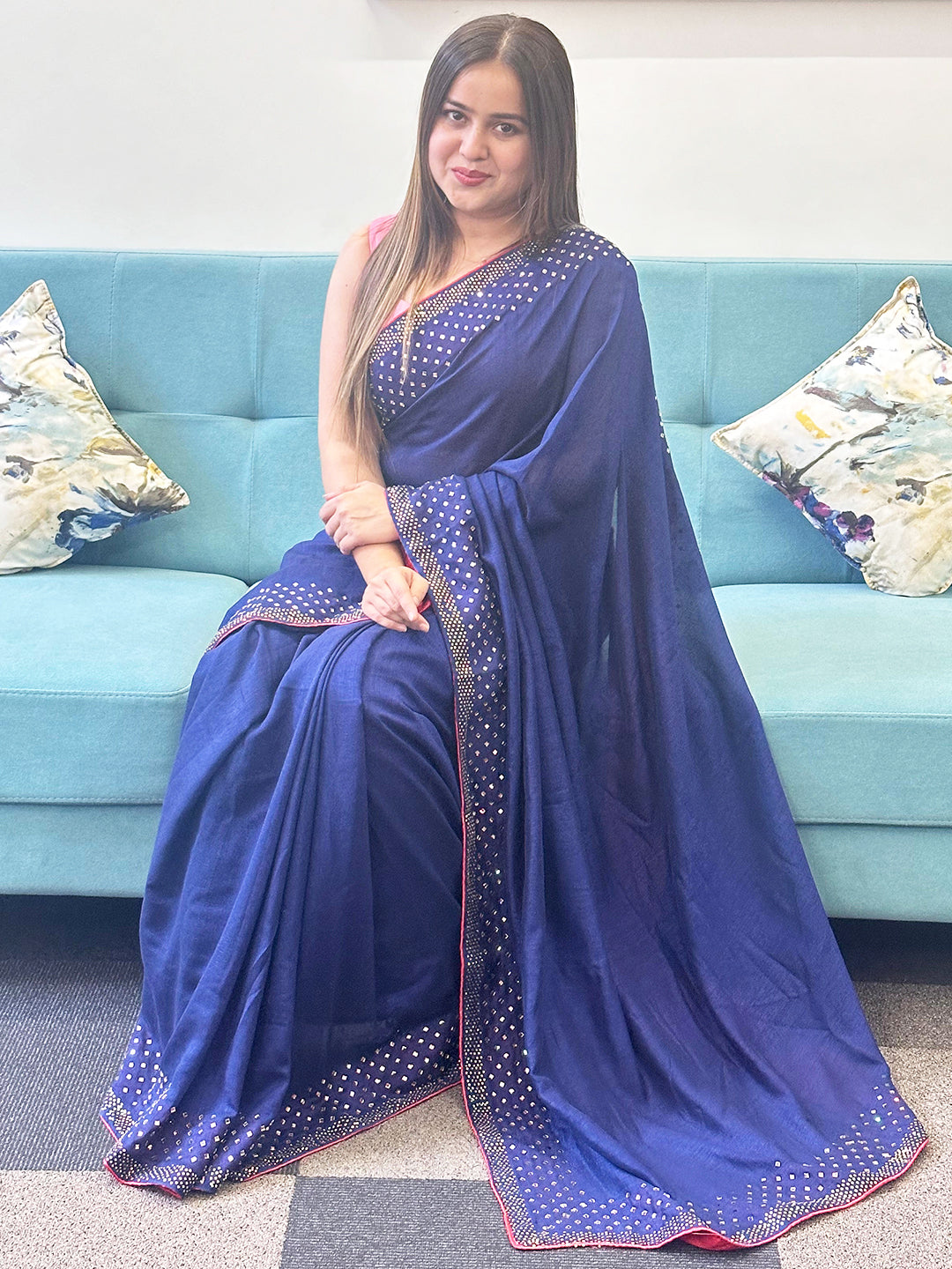 Navy silk saree with Swarovski stones, seated model.