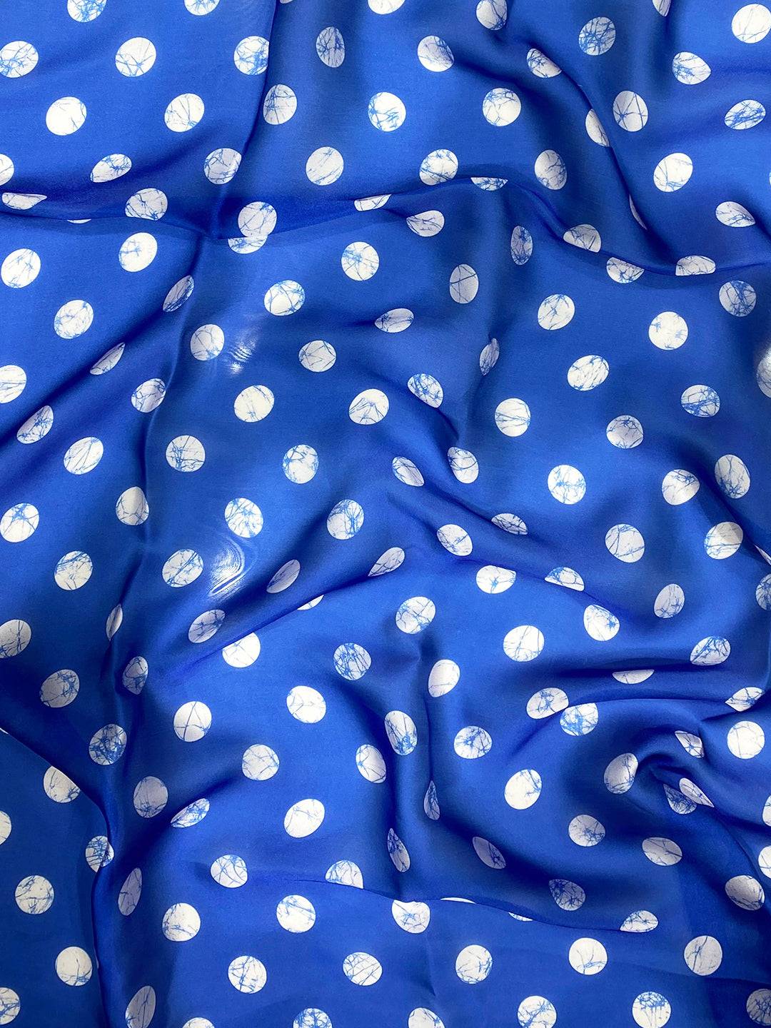 Close-up of blue fabric with white polka dot pattern