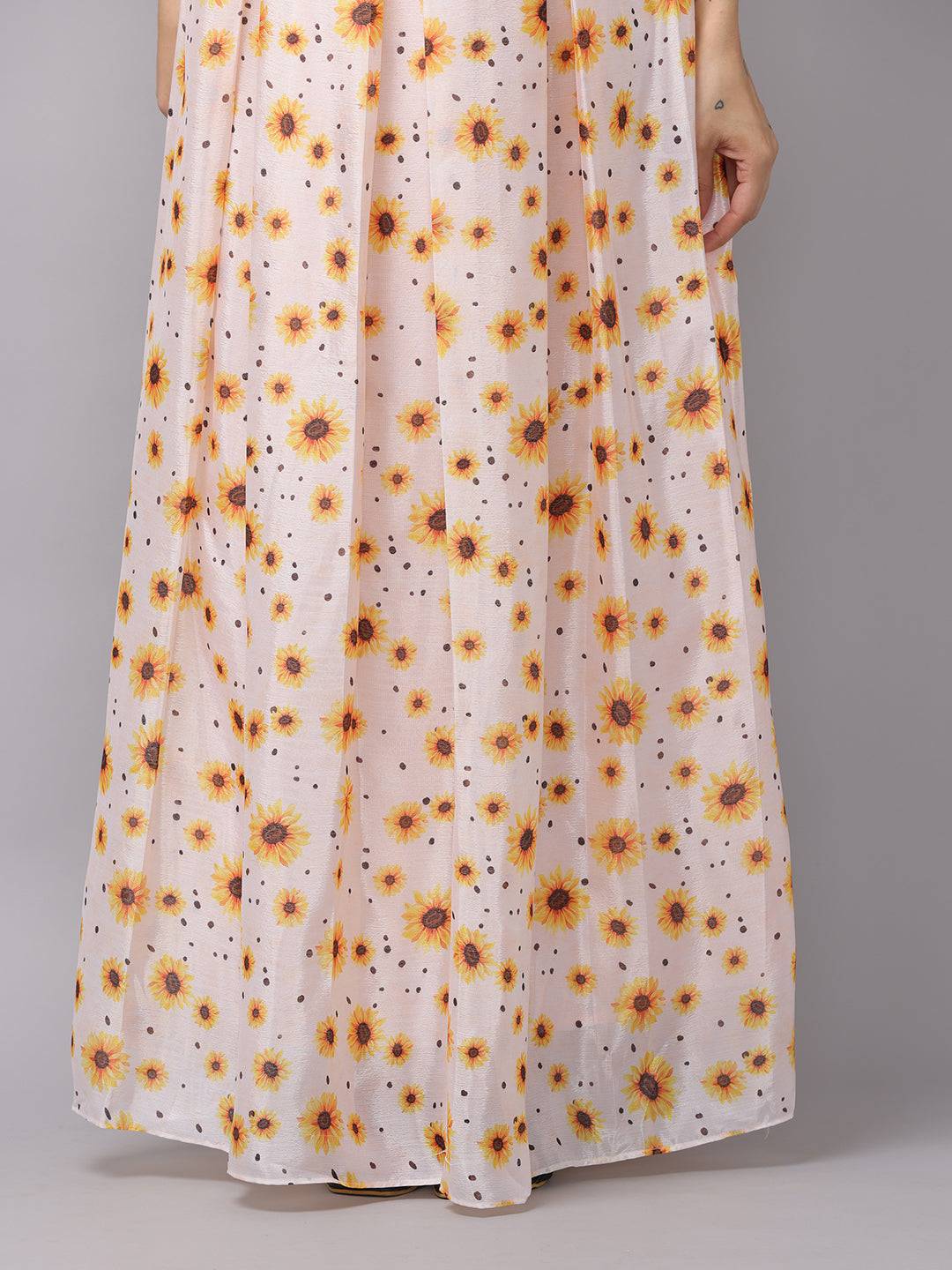 Detail of sunflower print on white maxi dress fabric.