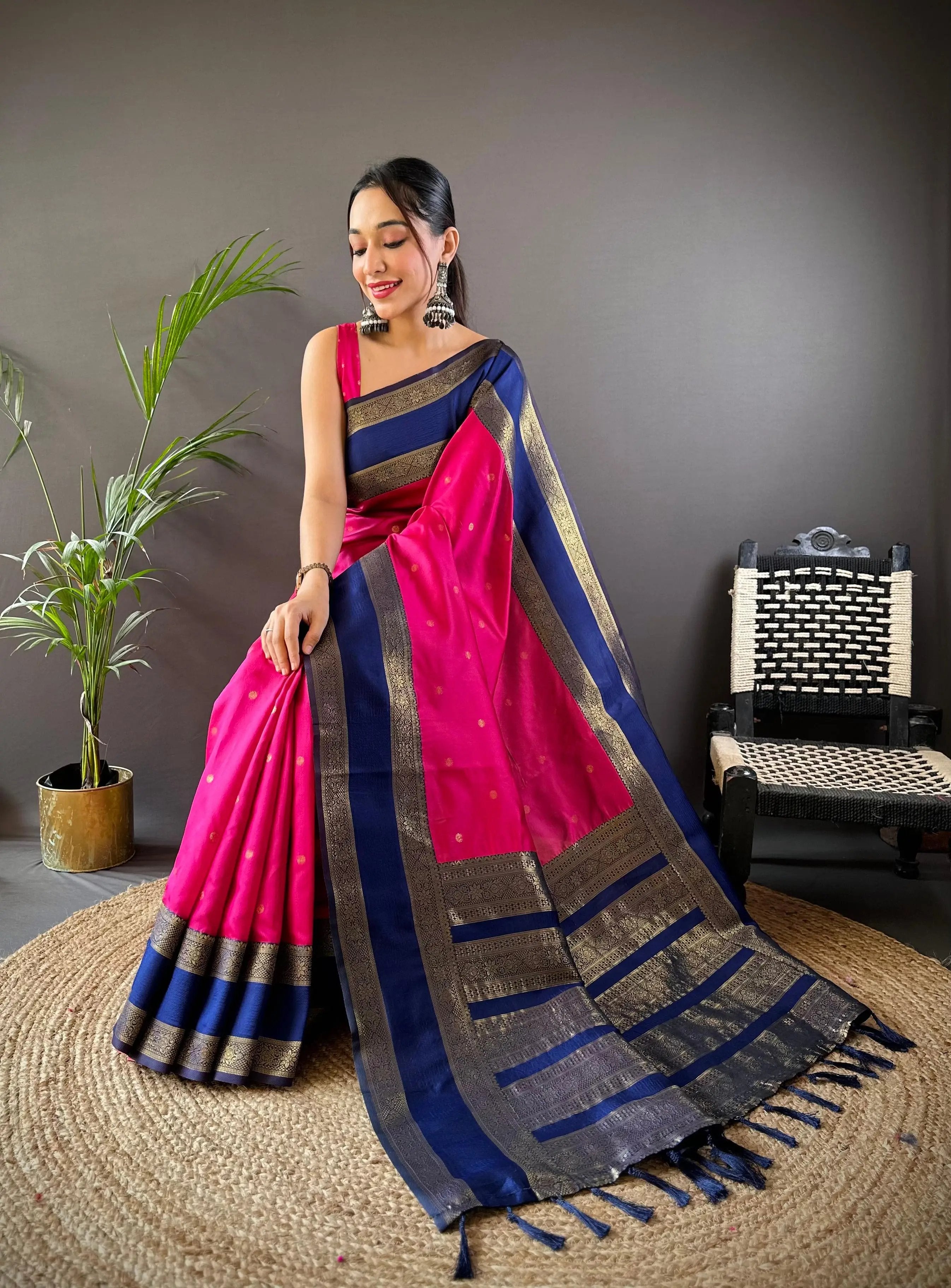 Model in vibrant pink and blue Banarasi saree with gold details