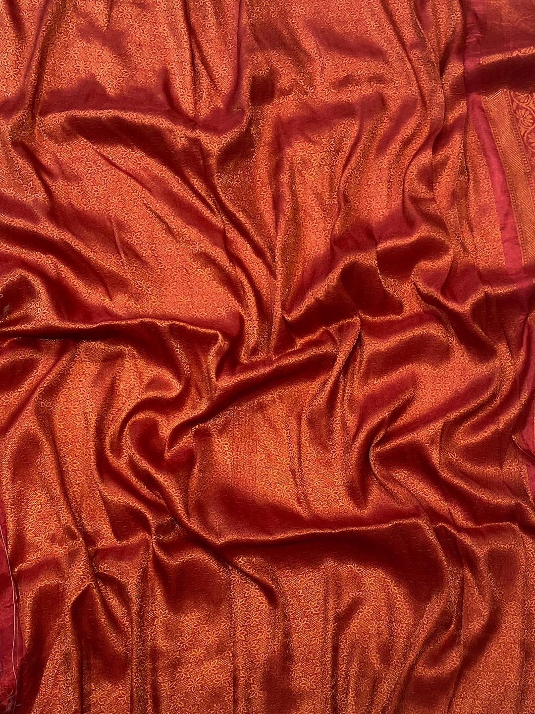 Close-up of red Patola saree fabric with detailed texture.