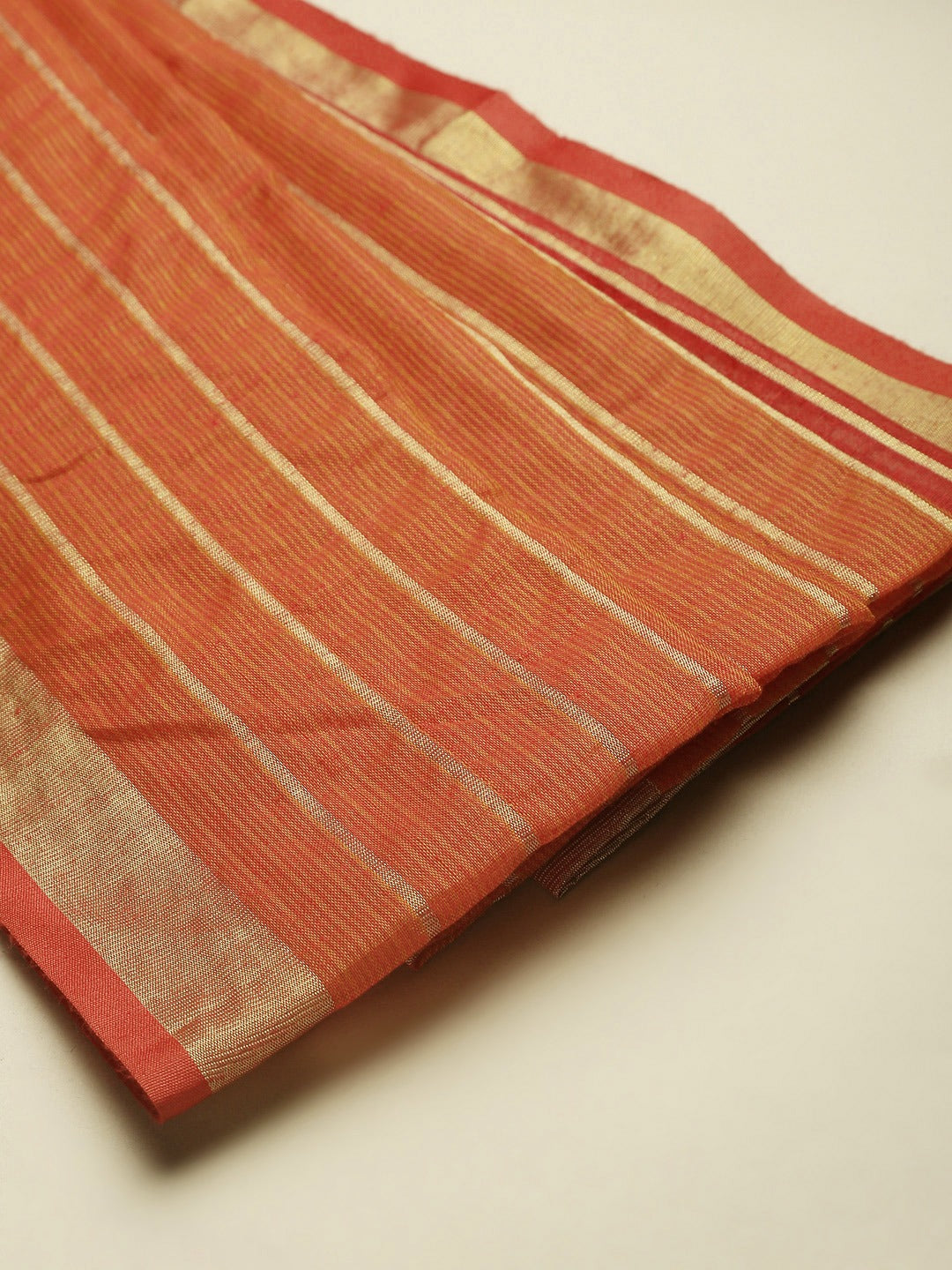 Folded orange Kota Doria saree with zari butti design